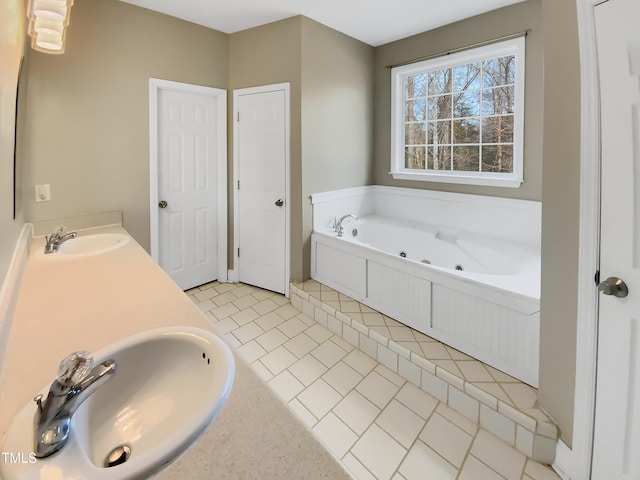 bathroom featuring double vanity, a sink, a jetted tub, and tile patterned floors