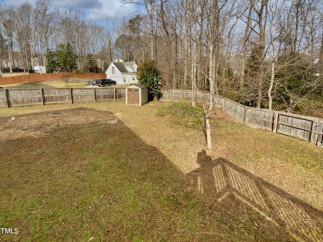 view of yard with an outbuilding, a storage shed, and a fenced backyard