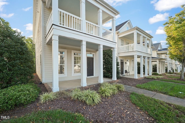 view of home's exterior with covered porch and a balcony