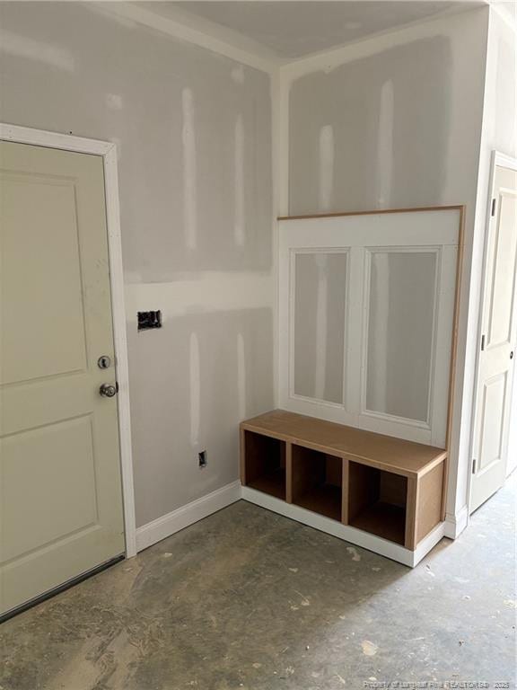 mudroom featuring baseboards and unfinished concrete floors