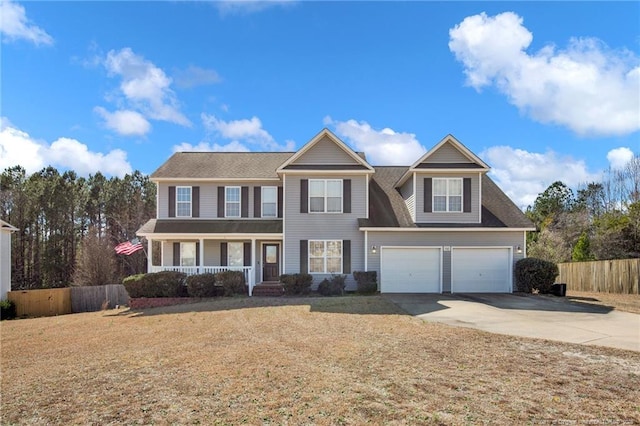 view of front facade with covered porch, fence, concrete driveway, and a front yard