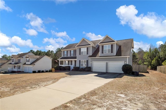 view of front facade with a garage, concrete driveway, and fence