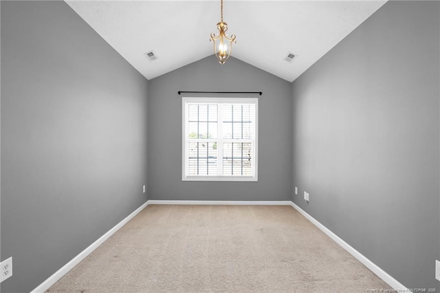 spare room with light carpet, visible vents, baseboards, and lofted ceiling