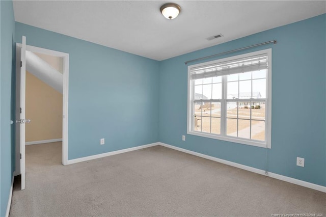 carpeted empty room with visible vents and baseboards