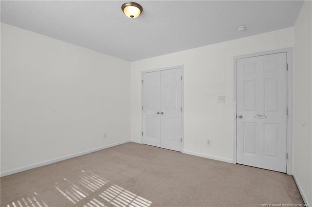 unfurnished bedroom featuring a closet, carpet flooring, and baseboards