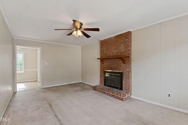 unfurnished living room with carpet floors, a brick fireplace, ceiling fan, and crown molding