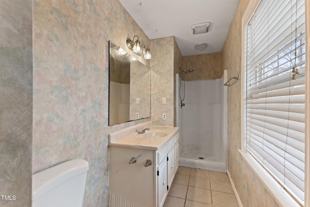 full bath featuring a shower, vanity, tile patterned flooring, and toilet