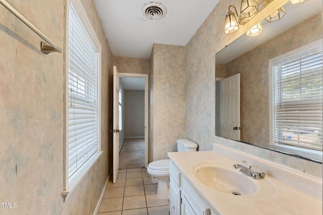 bathroom with toilet, vanity, visible vents, tile patterned floors, and wallpapered walls