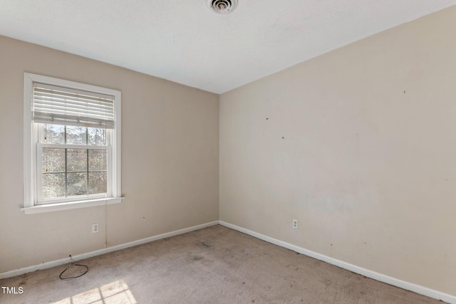 empty room featuring baseboards, visible vents, and carpet flooring