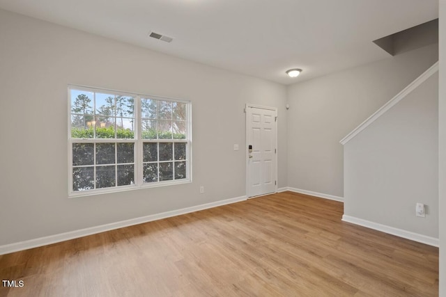 interior space with light wood-style floors, visible vents, and baseboards