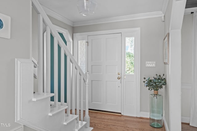 entryway with stairway, ornamental molding, baseboards, and wood finished floors