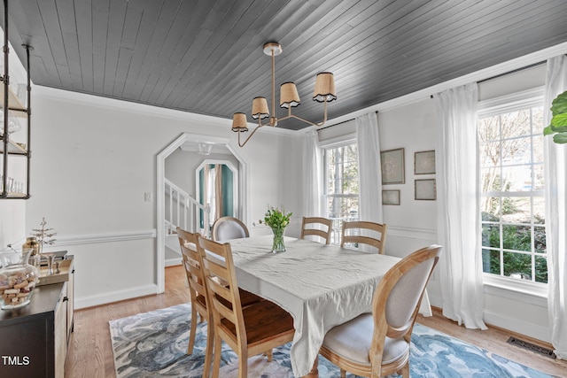 dining space with visible vents, a healthy amount of sunlight, light wood-type flooring, and ornamental molding