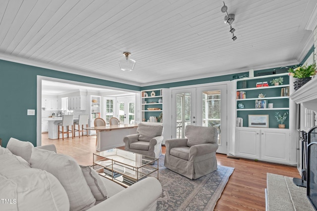 living area with rail lighting, french doors, light wood finished floors, and ornamental molding