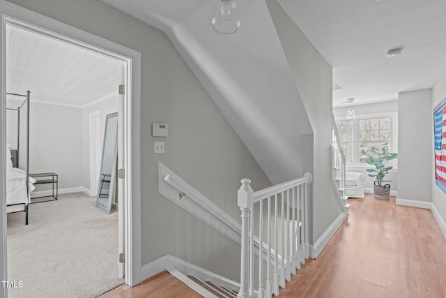 hall with wood finished floors, carpet flooring, an upstairs landing, and baseboards