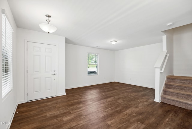 entrance foyer with dark wood-type flooring, baseboards, and stairs