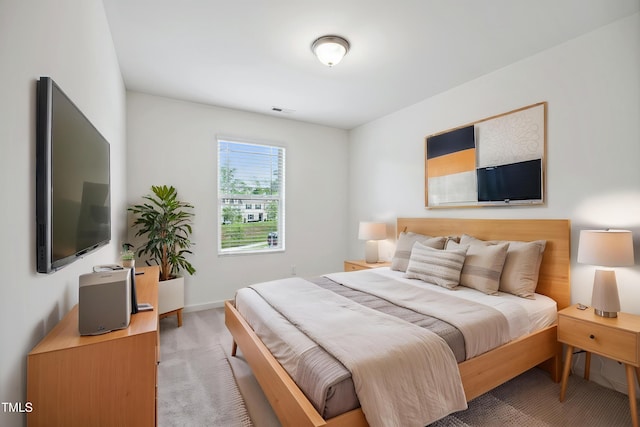 bedroom featuring light carpet and baseboards