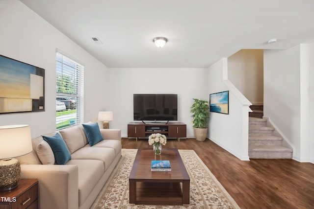living room with dark wood-style flooring, stairway, and baseboards