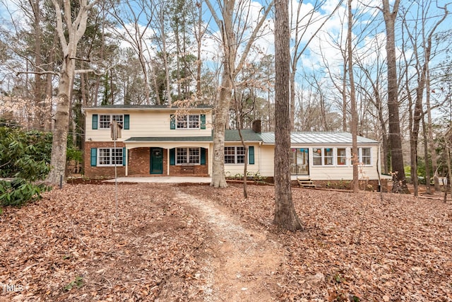 traditional-style home featuring brick siding and a chimney