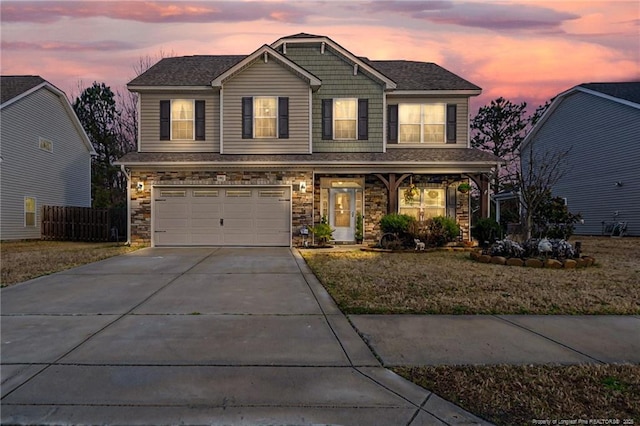 craftsman inspired home with stone siding, driveway, an attached garage, and fence