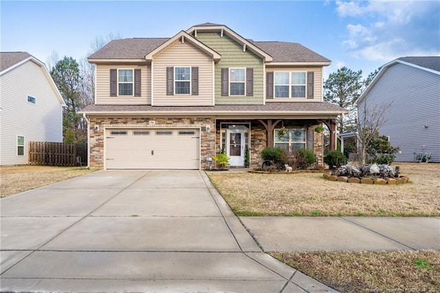 craftsman inspired home with an attached garage, driveway, stone siding, and fence