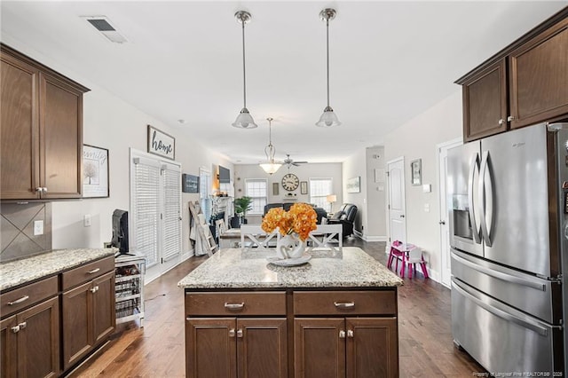 kitchen featuring dark brown cabinetry, dark wood-style floors, stainless steel fridge, and visible vents