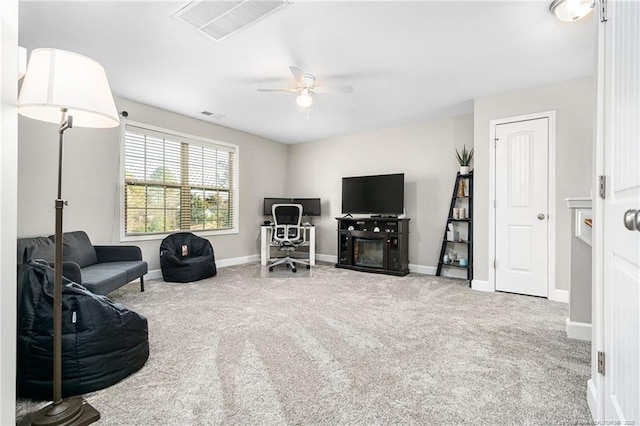 sitting room with baseboards, carpet floors, visible vents, and a ceiling fan