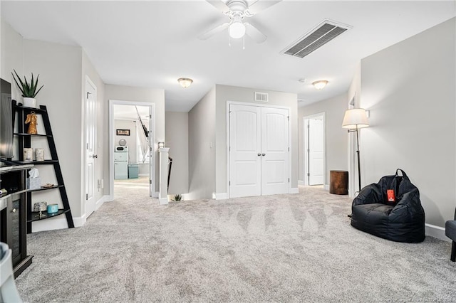 sitting room featuring baseboards, visible vents, carpet flooring, and an upstairs landing