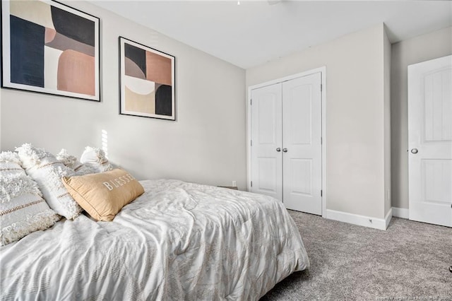 bedroom with a closet, carpet flooring, and baseboards