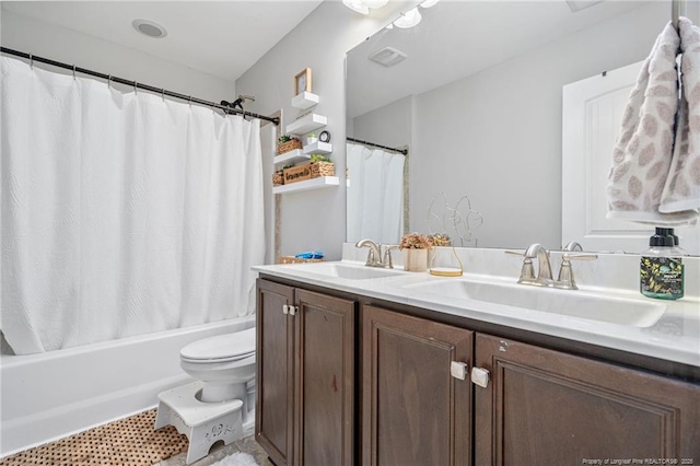 full bath with double vanity, toilet, shower / bath combo with shower curtain, and a sink