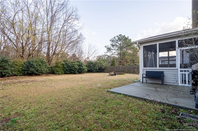 view of yard with a sunroom, fence, and a patio