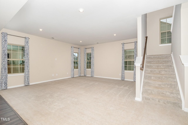 unfurnished living room with stairs, recessed lighting, baseboards, and light carpet