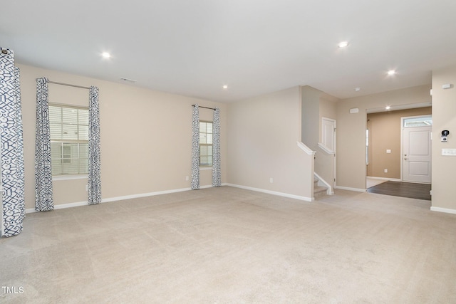 carpeted empty room with recessed lighting, stairway, and baseboards