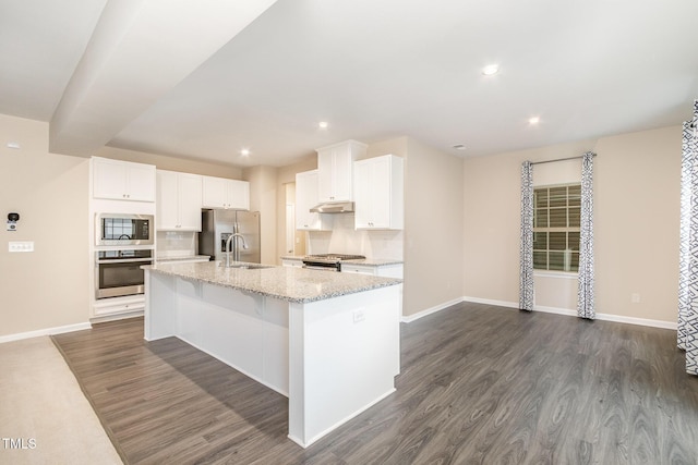 kitchen with a kitchen island with sink, a sink, dark wood-style floors, appliances with stainless steel finishes, and baseboards