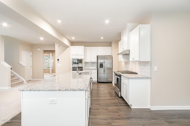 kitchen with under cabinet range hood, a sink, tasteful backsplash, stainless steel appliances, and white cabinets