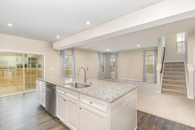 kitchen with a center island with sink, a sink, open floor plan, white cabinetry, and dishwasher