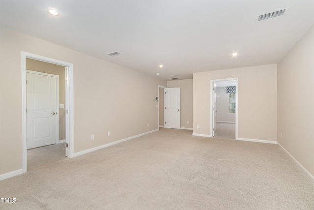 unfurnished bedroom with light carpet, visible vents, and baseboards