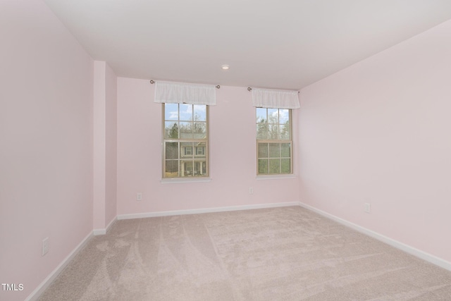 carpeted spare room featuring baseboards