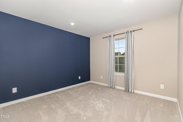 unfurnished room with carpet and baseboards