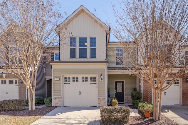 view of front of property with stone siding, board and batten siding, concrete driveway, and a garage