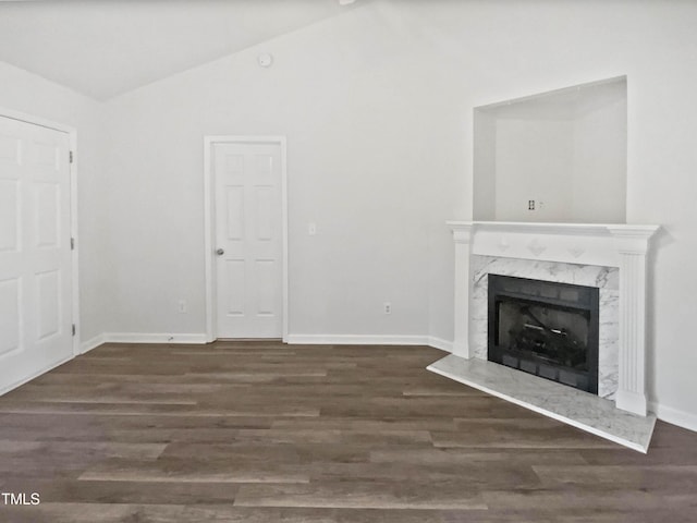 unfurnished living room featuring a fireplace, baseboards, vaulted ceiling, and wood finished floors