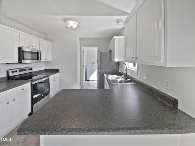 kitchen featuring white cabinets, dark countertops, washer / clothes dryer, stainless steel appliances, and a sink