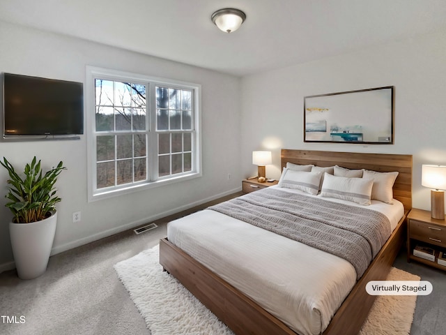 carpeted bedroom with visible vents and baseboards