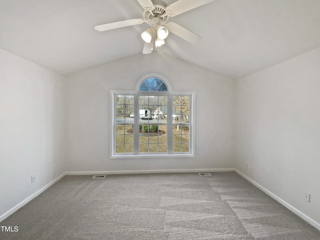 carpeted spare room featuring ceiling fan, visible vents, vaulted ceiling, and baseboards