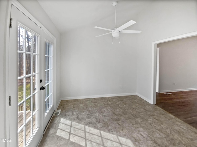 spare room with a healthy amount of sunlight, baseboards, vaulted ceiling, and a ceiling fan