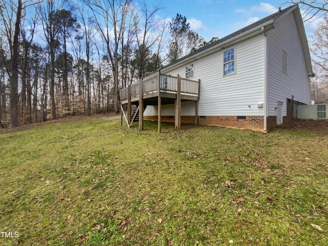 back of house with crawl space, stairway, a deck, and a yard