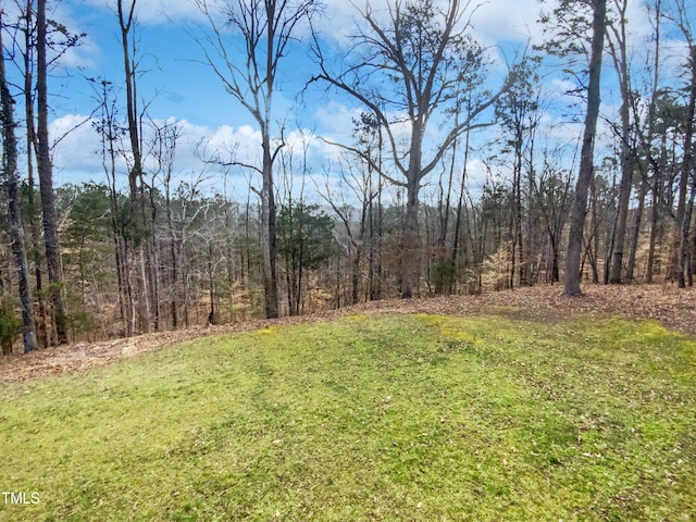 view of yard with a view of trees