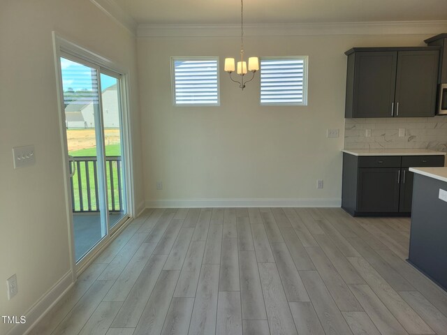 3703 Cessna Way Unit 9, Wilson, NC 27896 - unfurnished dining area featuring a chandelier, light wood-style floors, crown molding, and baseboards