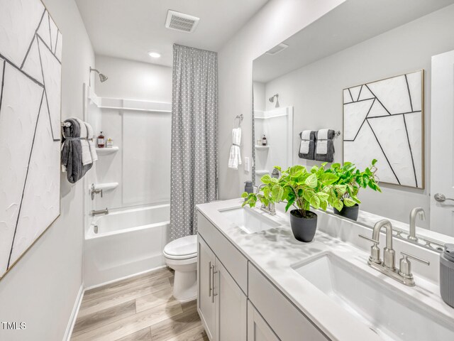 full bathroom featuring a sink, visible vents, toilet, and wood finished floors