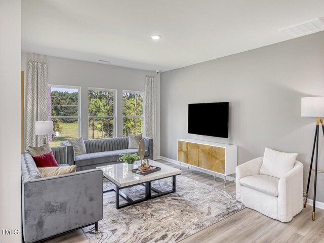 living area featuring recessed lighting, visible vents, baseboards, and wood finished floors