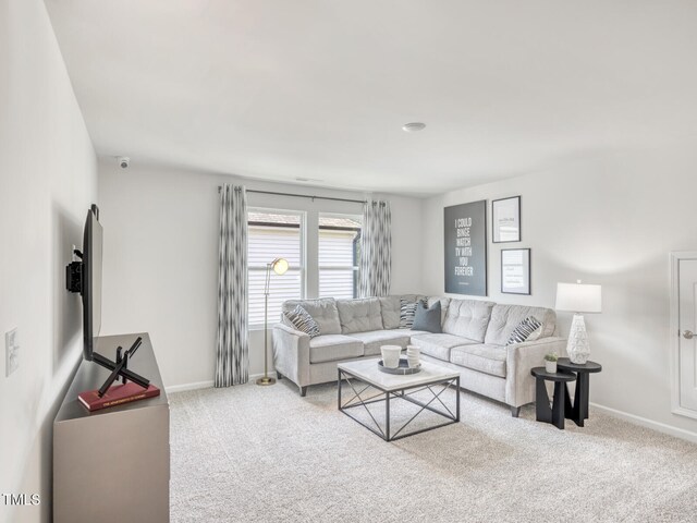 carpeted living room featuring baseboards